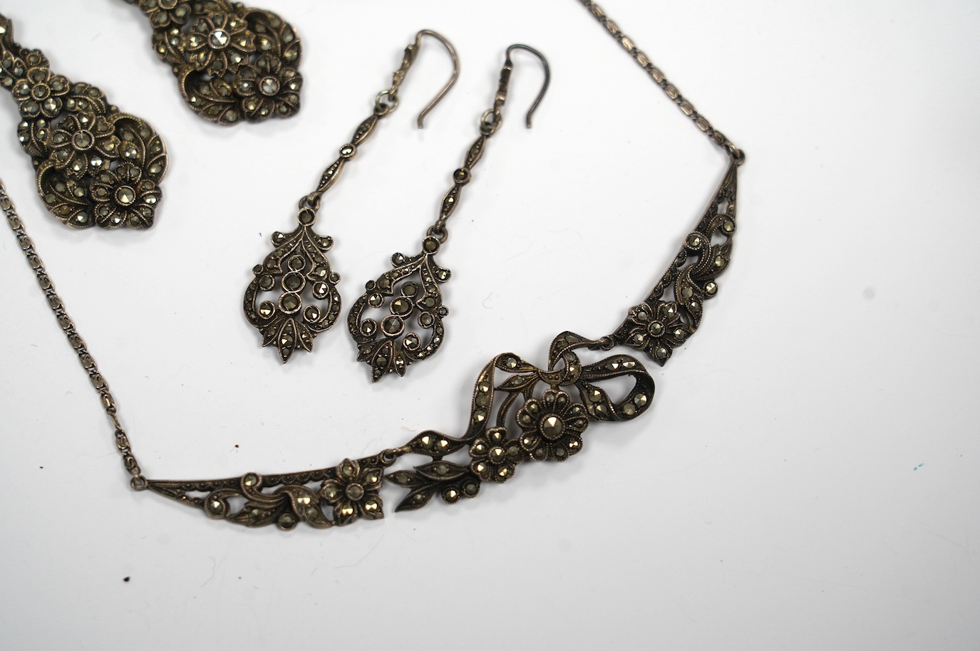 Two pairs of white metal and marcasite earrings, a similar pair of ear clips and a necklace. Condition - poor to fair